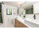 Modern bathroom with double sinks, sleek fixtures, stylish mirrors, and well-lit vanity, offering a clean and fresh design at 2899 Emporia Ct, Denver, CO 80238