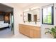 Chic bathroom featuring a double vanity, modern lighting, and a glimpse of the bedroom, blending style and functionality at 2899 Emporia Ct, Denver, CO 80238