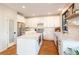 Modern kitchen with white cabinets, stainless steel appliances, and center island at 2899 Emporia Ct, Denver, CO 80238