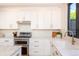 Bright kitchen with white cabinets, stainless appliances, and stylish fixtures at 2899 Emporia Ct, Denver, CO 80238