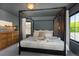 Elegant main bedroom featuring a distinctive four-poster bed, sophisticated decor, and ample natural light from large windows at 2899 Emporia Ct, Denver, CO 80238