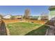 Large fenced backyard with mature trees and a well-maintained lawn at 375 Longspur Dr, Brighton, CO 80601