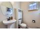 Powder bathroom featuring pedestal sink, storage cabinet, and framed mirror at 375 Longspur Dr, Brighton, CO 80601