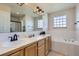Bright bathroom featuring double sinks, soaking tub, and walk-in shower at 375 Longspur Dr, Brighton, CO 80601