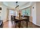 Elegant dining room with a rustic wooden table, modern lighting, and natural light from a window at 375 Longspur Dr, Brighton, CO 80601
