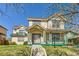 Charming two-story home with a covered porch and well-manicured lawn offers curb appeal at 375 Longspur Dr, Brighton, CO 80601