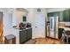 Well-equipped kitchen featuring stainless steel refrigerator, green cabinets, and hardwood floors at 375 Longspur Dr, Brighton, CO 80601