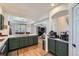 Open kitchen featuring green cabinets, stainless appliances, and breakfast nook area at 375 Longspur Dr, Brighton, CO 80601
