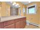 Yellow bathroom with a large mirror, vanity, and a glass-enclosed shower at 960 S Arbutus St, Lakewood, CO 80228