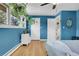 Bright bedroom with blue walls, hardwood floors, and a window with hanging plants at 960 S Arbutus St, Lakewood, CO 80228
