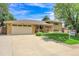 Charming brick home featuring a two-car garage, covered entryway, and well-manicured lawn at 960 S Arbutus St, Lakewood, CO 80228
