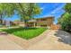 Charming brick home featuring a two-car garage, covered entryway, and well-manicured lawn at 960 S Arbutus St, Lakewood, CO 80228