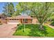 Charming home with mature trees, lush lawn, manicured landscaping, and a brick exterior at 960 S Arbutus St, Lakewood, CO 80228
