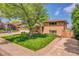 Charming home with mature trees, lush lawn, manicured landscaping, and a brick exterior at 960 S Arbutus St, Lakewood, CO 80228