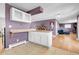 A kitchen and adjacent room featuring tile and hardwood floors with purple walls at 960 S Arbutus St, Lakewood, CO 80228