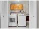 Laundry room with washer, dryer, storage cabinets, and bi-fold doors at 960 S Arbutus St, Lakewood, CO 80228