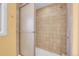 Bathroom shower with tan tile and a glass shower door at 960 S Arbutus St, Lakewood, CO 80228