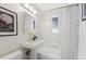 Well-lit bathroom with a pedestal sink, tiled shower/tub, and stylish fixtures creating a functional space at 1080 S Garfield St, Denver, CO 80209