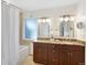 Elegant bathroom with double sinks, granite countertops, and a bathtub shower combination at 1080 S Garfield St, Denver, CO 80209