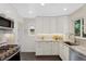 Well-lit kitchen features stainless steel appliances, white cabinets, and tile backsplash at 1080 S Garfield St, Denver, CO 80209