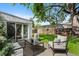 Charming outdoor patio with comfortable seating, lush lawn, mature shade trees, and access to the home at 1080 S Garfield St, Denver, CO 80209