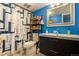 Bathroom featuring a blue accent wall, modern vanity, and patterned shower curtain, offering a refreshing design at 1260 York St # 102, Denver, CO 80206