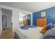 Bedroom with a large closet mirror and a bright blue accent wall, creating a peaceful retreat at 1260 York St # 102, Denver, CO 80206