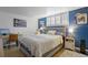 Charming bedroom with bright white and blue accents, featuring a comfortable bed, desk, and modern decor at 1260 York St # 102, Denver, CO 80206