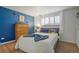 Comfortable bedroom with a modern design, featuring a bright blue accent wall and cozy furnishings at 1260 York St # 102, Denver, CO 80206
