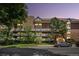 Apartment building exterior features stone accents, balconies, mature landscaping, and available parking at 1260 York St # 102, Denver, CO 80206