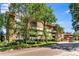 Brick building on the street with beautiful landscaped grounds, mature trees, and a view of the neighborhood at 1260 York St # 102, Denver, CO 80206
