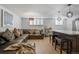 Spacious living area showcasing a comfortable leather sectional sofa, bar cart, and bright shuttered windows at 1260 York St # 102, Denver, CO 80206