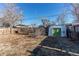 Large backyard features a storage shed, partial fence, and bare trees at 7856 Ladore St, Commerce City, CO 80022