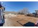 Inviting backyard features a wood deck, partial fence, and clear blue skies at 7856 Ladore St, Commerce City, CO 80022