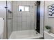 Clean and modern bathroom features a shower-tub, modern fixtures, and sleek white tiles at 7856 Ladore St, Commerce City, CO 80022