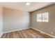 Well-lit bedroom with wood floors, neutral walls, and window overlooking the backyard at 7856 Ladore St, Commerce City, CO 80022