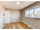 Another view of bedroom, showing hardwood floors and large window with neighborhood view at 7856 Ladore St, Commerce City, CO 80022