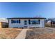 Inviting single-story home with neutral siding, black shutters, and a neatly landscaped front yard at 7856 Ladore St, Commerce City, CO 80022