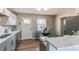 Stylish eat-in kitchen featuring new appliances, marble countertops, and modern lighting fixtures at 7856 Ladore St, Commerce City, CO 80022