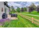 Outdoor patio with covered grill, lush grass, walking path and colorful flowers at 3070 Redhaven Way, Highlands Ranch, CO 80126