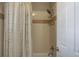 Bathroom shower with a decorative shower curtain and an adjustable shower head with shelves at 3070 Redhaven Way, Highlands Ranch, CO 80126