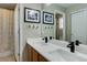 Dual sinks, a large mirror, decorative turtle art, and vanity lighting in this cozy and bright bathroom at 3070 Redhaven Way, Highlands Ranch, CO 80126