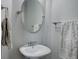 Stylish powder room featuring oval mirror, sink, chrome fixtures and decorative towels at 3070 Redhaven Way, Highlands Ranch, CO 80126