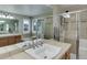 Elegant bathroom featuring dual sinks, tiled countertops, and a glass-enclosed shower at 3070 Redhaven Way, Highlands Ranch, CO 80126