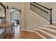 Inviting home foyer with hardwood floors, a staircase with a black iron railing, and arched doorways at 3070 Redhaven Way, Highlands Ranch, CO 80126