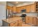 Well-appointed kitchen featuring wood cabinetry, stainless steel appliances, and a kitchen island at 3070 Redhaven Way, Highlands Ranch, CO 80126