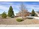 Well-maintained single-story home featuring manicured landscaping with rock ground cover and mature trees at 5480 Craftsman Dr, Parker, CO 80134