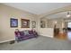 Bright living room featuring neutral walls, carpeted flooring, an open archway, and decorative furnishings at 5480 Craftsman Dr, Parker, CO 80134