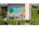 Overhead view of a pristine swimming pool with lounging areas, surrounded by lush lawns and mature trees at 12760 Ironstone Way # 103, Parker, CO 80134