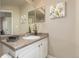 Well-lit bathroom vanity featuring framed mirror, floral arrangement, and neutral finishes at 12760 Ironstone Way # 103, Parker, CO 80134